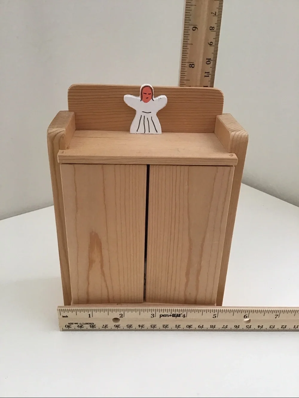 Handmade wooden cabinet holding a small wooden Nativity set